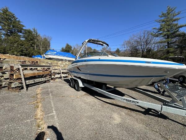 Crownline E255 2024 Crownline E Series E255 boat on trailer in outdoor storage area.