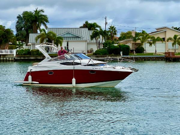 Regal 30 Express 2015 Regal 30 Express boat on calm water near waterfront homes.