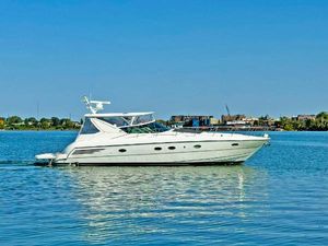 Trojan 440 Express 1998 Trojan 440 Express yacht cruising on a calm, blue waterway.