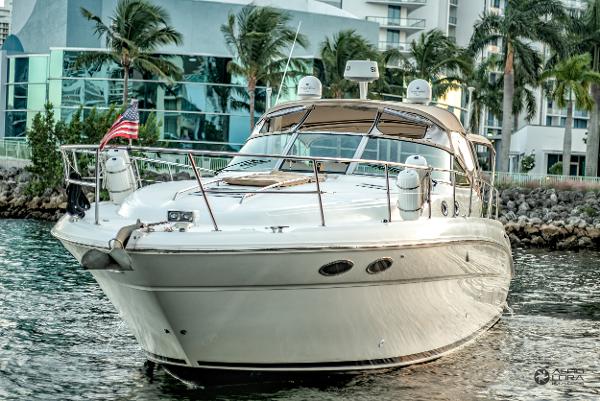 Sea Ray 380 Sundancer 2002 Sea Ray 380 Sundancer yacht docked near modern buildings and palm trees.