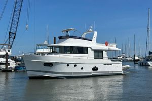 Beneteau Swift Trawler 50 2019 Beneteau Swift Trawler 50 yacht docked in a marina under clear blue skies.