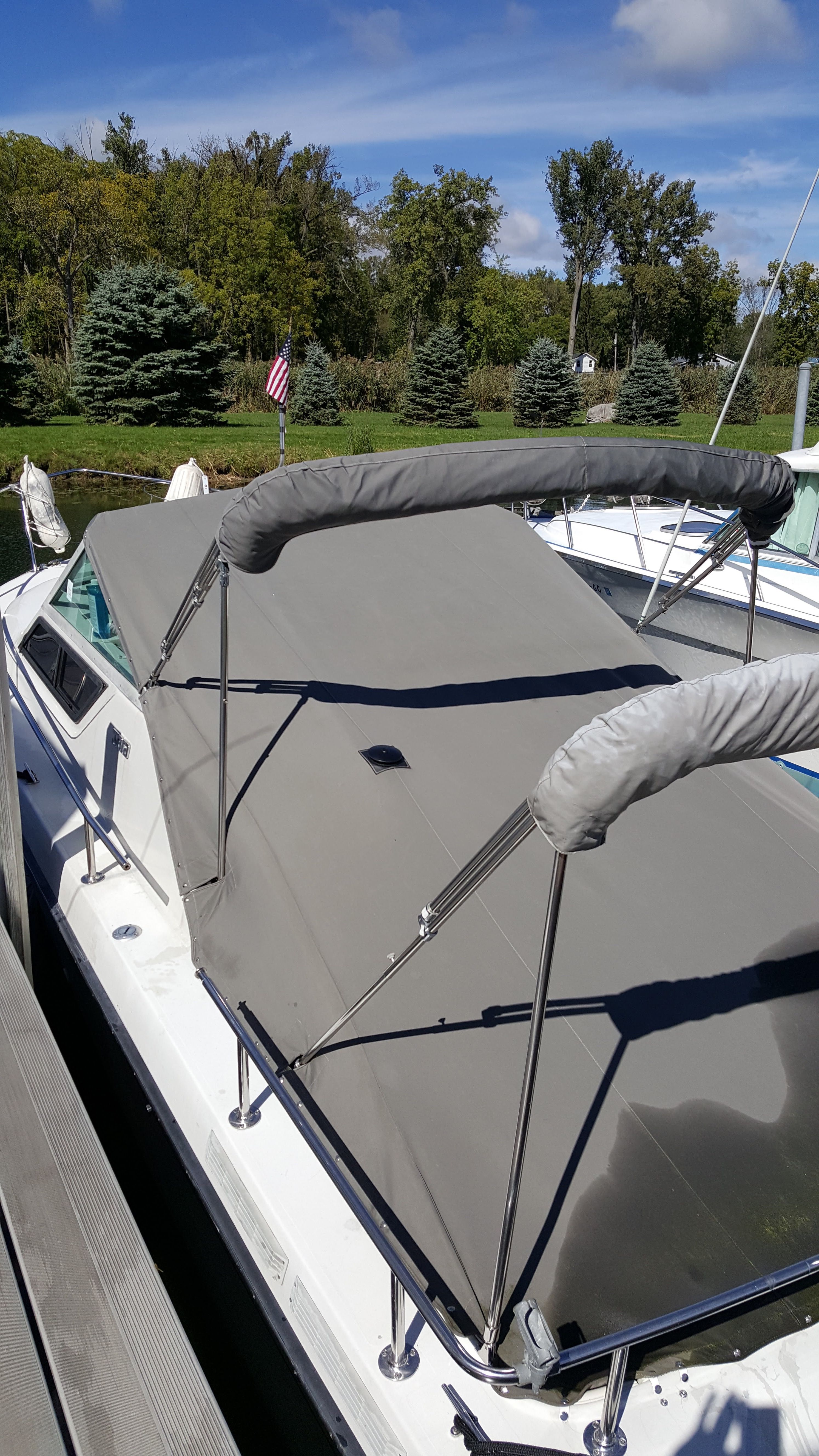 Tiara Yachts 2700 Continental 1986 Tiara Yachts 2700 Continental with gray cover docked near trees.