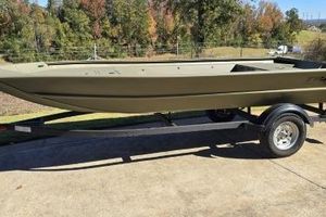 Tracker Grizzly 1754 Jon 2025 Tracker Grizzly 1754 Jon boat on trailer, outdoors with autumn trees in background.