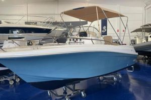 Jeanneau Cap Camarat 6.5 CC 2011 Jeanneau Cap Camarat 6.5 CC boat with blue hull and canopy in showroom.