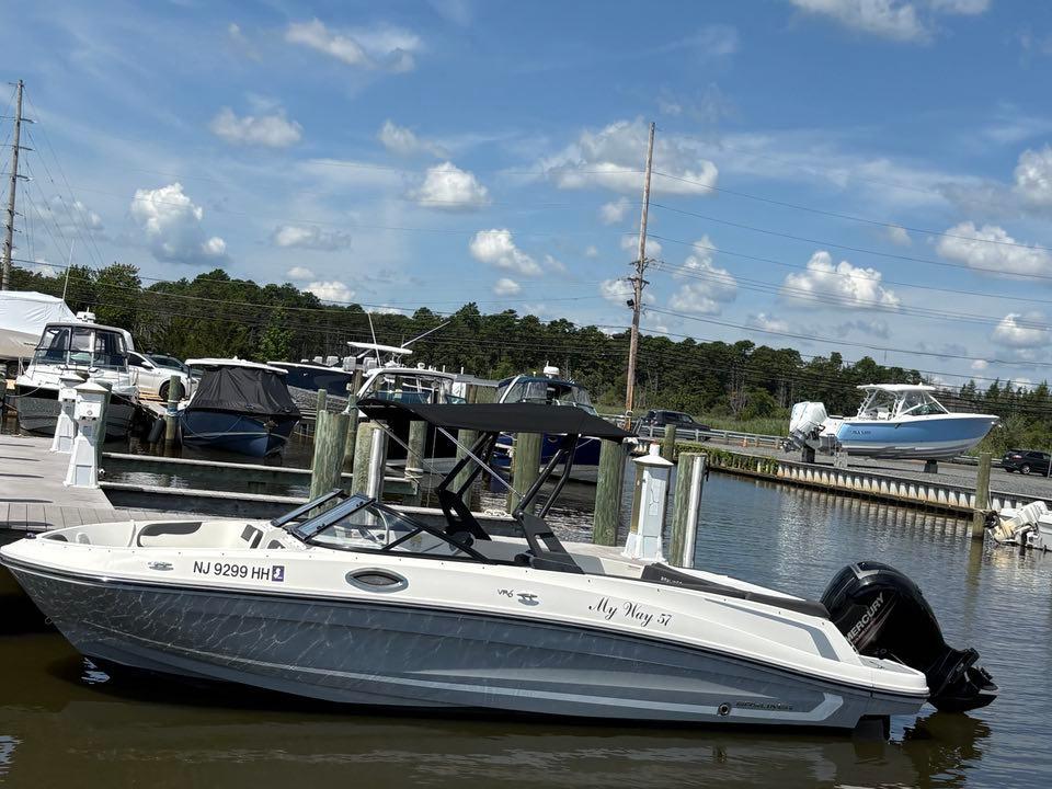 Bayliner VR6 2019 Bayliner VR6 boat docked at marina under blue sky.