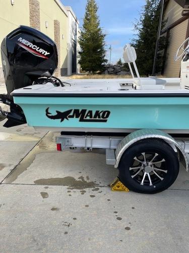 Mako 18 LTS 2025 Mako 18 LTS boat on trailer with Mercury engine, parked outdoors.