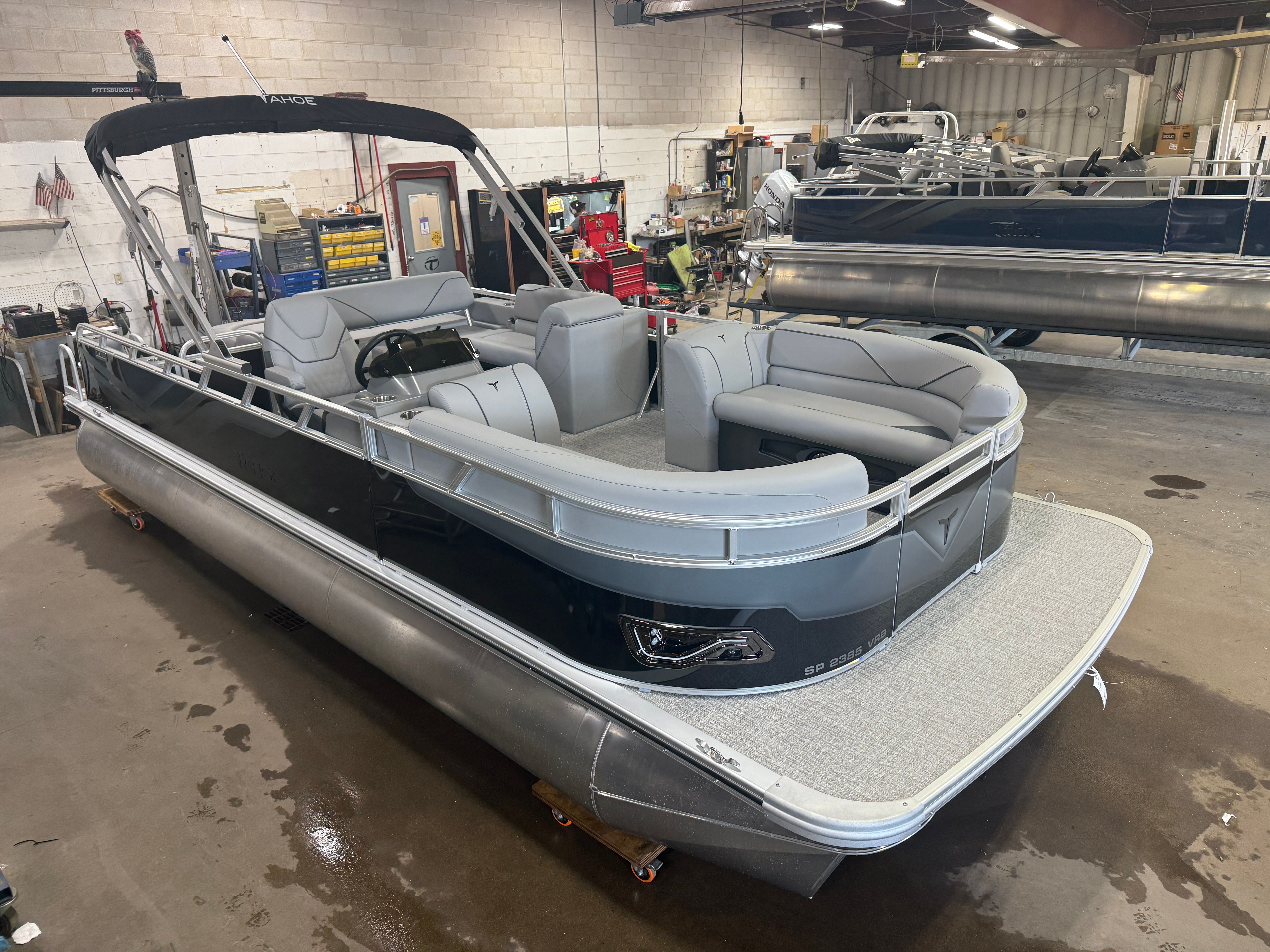 Tahoe Sport 2385 Swingback (VRB) & Honda 4-Stroke EFI 2025 Tahoe Sport 2385 Swingback pontoon boat in a workshop setting.