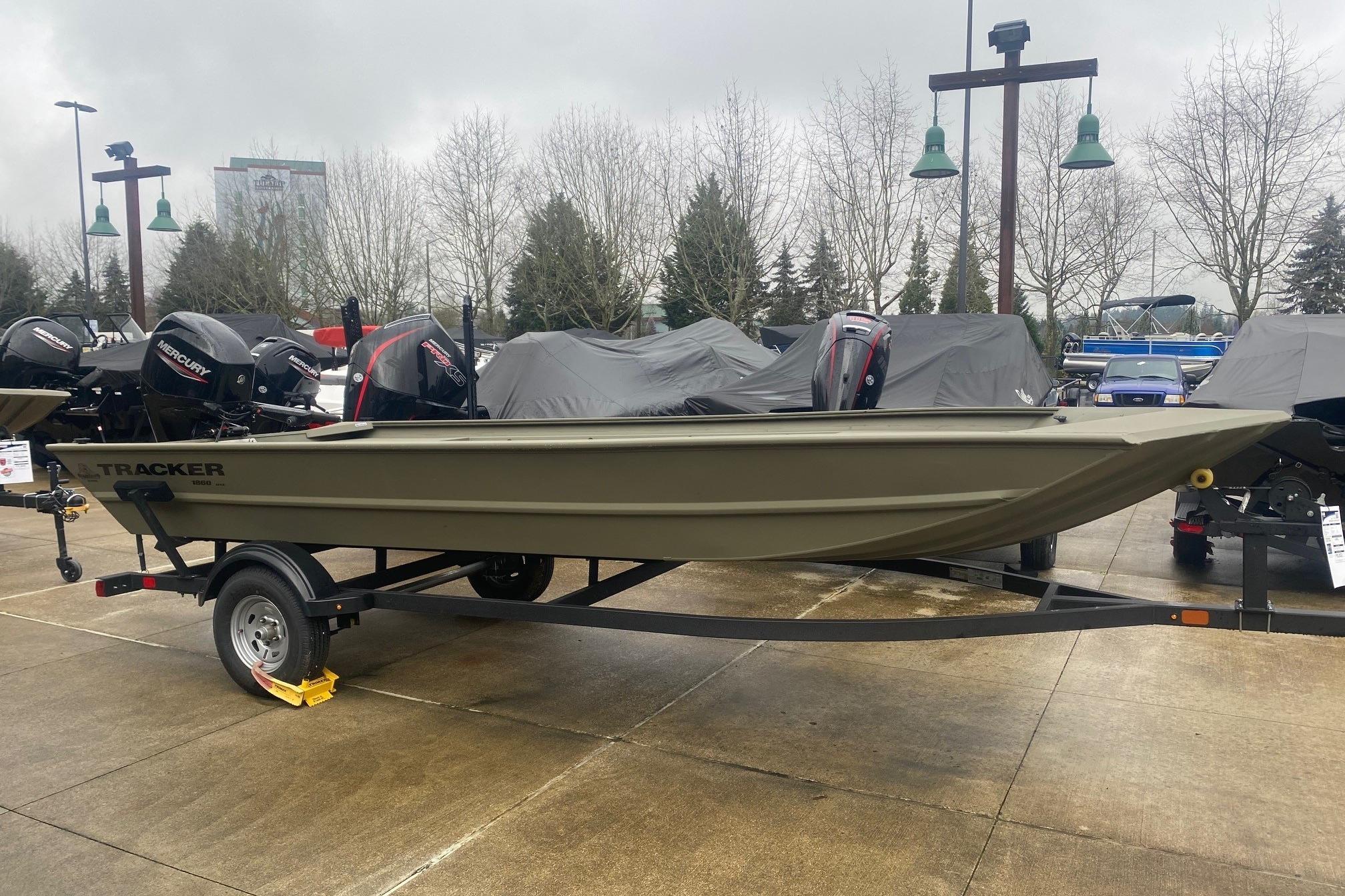 Tracker Grizzly 1860 Utility 2025 Tracker Grizzly 1860 Utility boat on trailer, parked outdoors on a cloudy day.