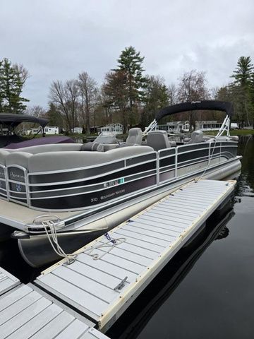 Premier Boundary Water 2016 Premier Boundary Water pontoon boat docked on a calm lake.