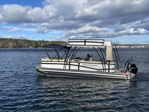 Premier 250 Solaris Upper Deck 2024 Premier 250 Solaris Upper Deck pontoon boat on a scenic lake.