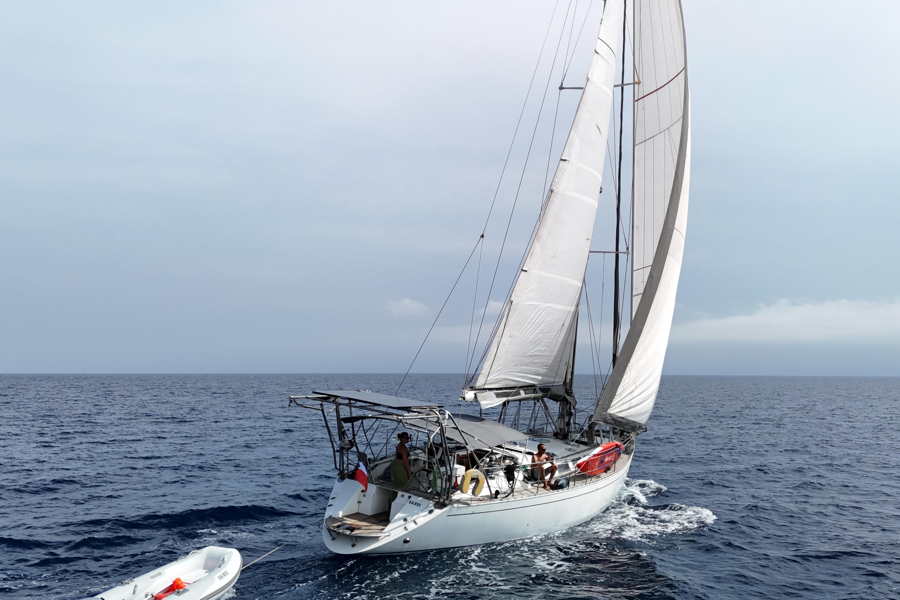Dufour 54 Prestige Sailing yacht Dufour 54 Prestige 1996 navigating open sea with dinghy in tow.