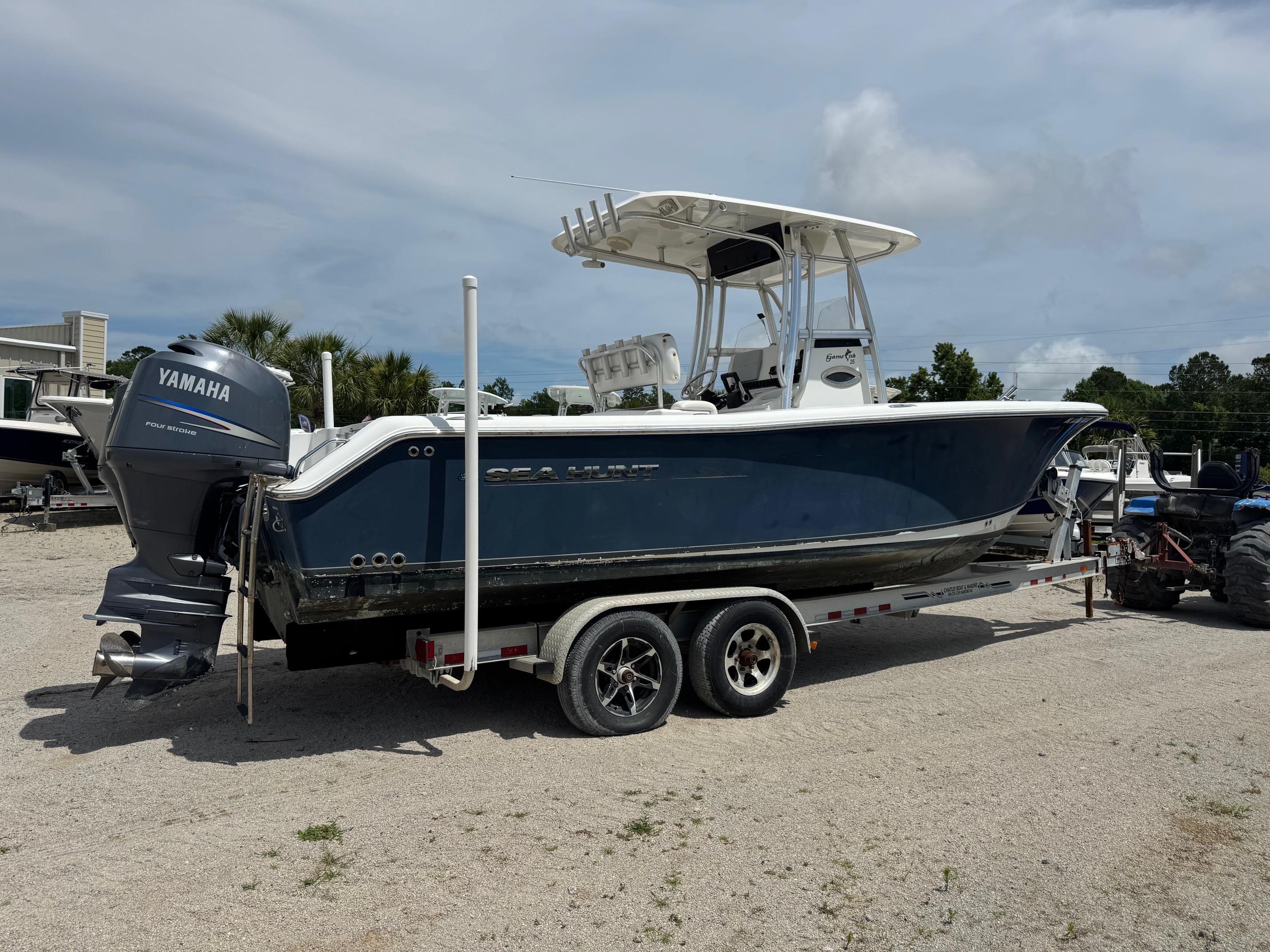 Sea Hunt Gamefish 25 2011 Sea Hunt Gamefish 25 boat on trailer with Yamaha engine, parked outdoors.