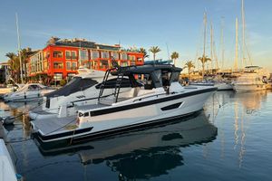 Bluegame BG42 2024 Bluegame BG42 yacht docked in a marina with vibrant buildings and palm trees.