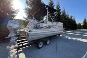 Godfrey Sweetwater 2013 Godfry Sweetwater pontoon boat on trailer with Honda outboard motor, parked outdoors.