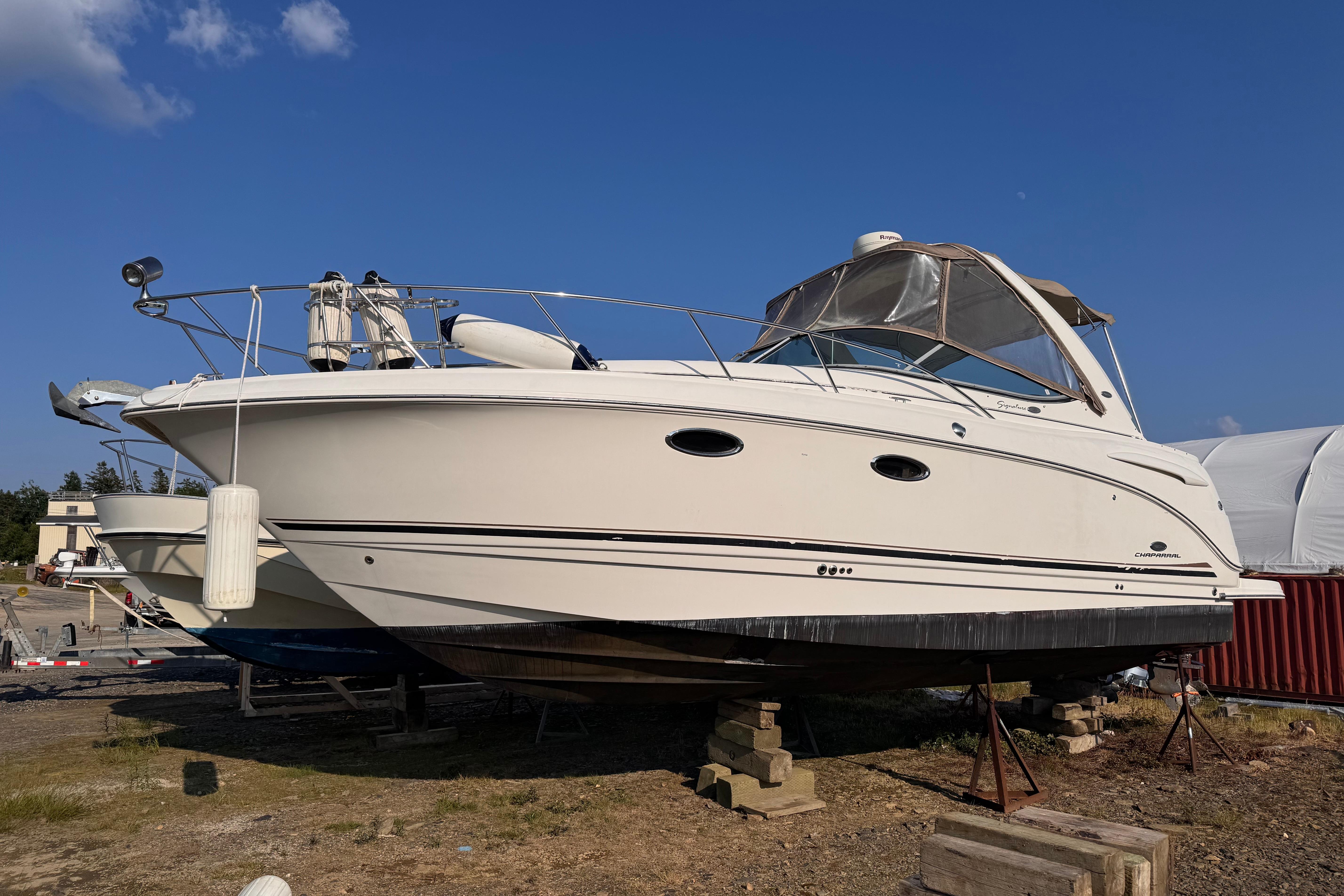 Chaparral Signature 310 2005 Chaparral Signature 310 boat on dry dock under clear blue sky.