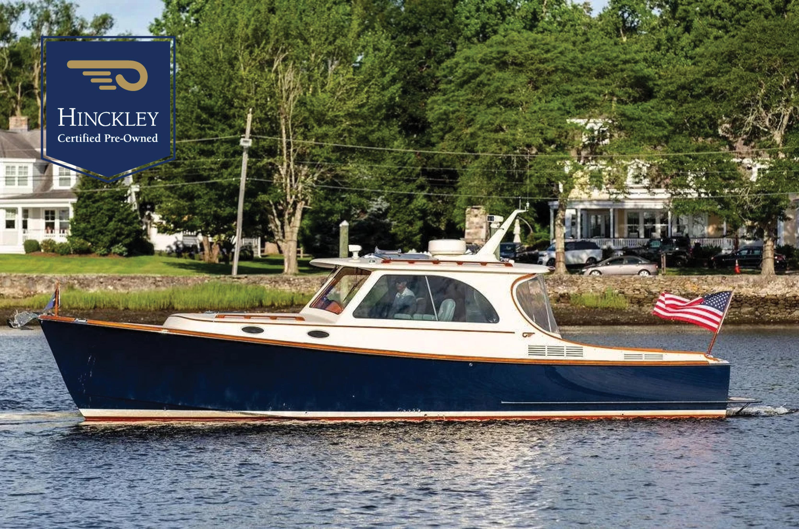 Hinckley Picnic Boat Mark III 2011 Hinckley Picnic Boat Mark III cruising on a river, certified pre-owned, with American flag.