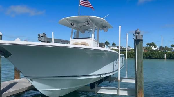 Sea Hunt Gamefish 30 2015 Sea Hunt Gamefish 30 boat docked with American flag, clear sky, and calm water.