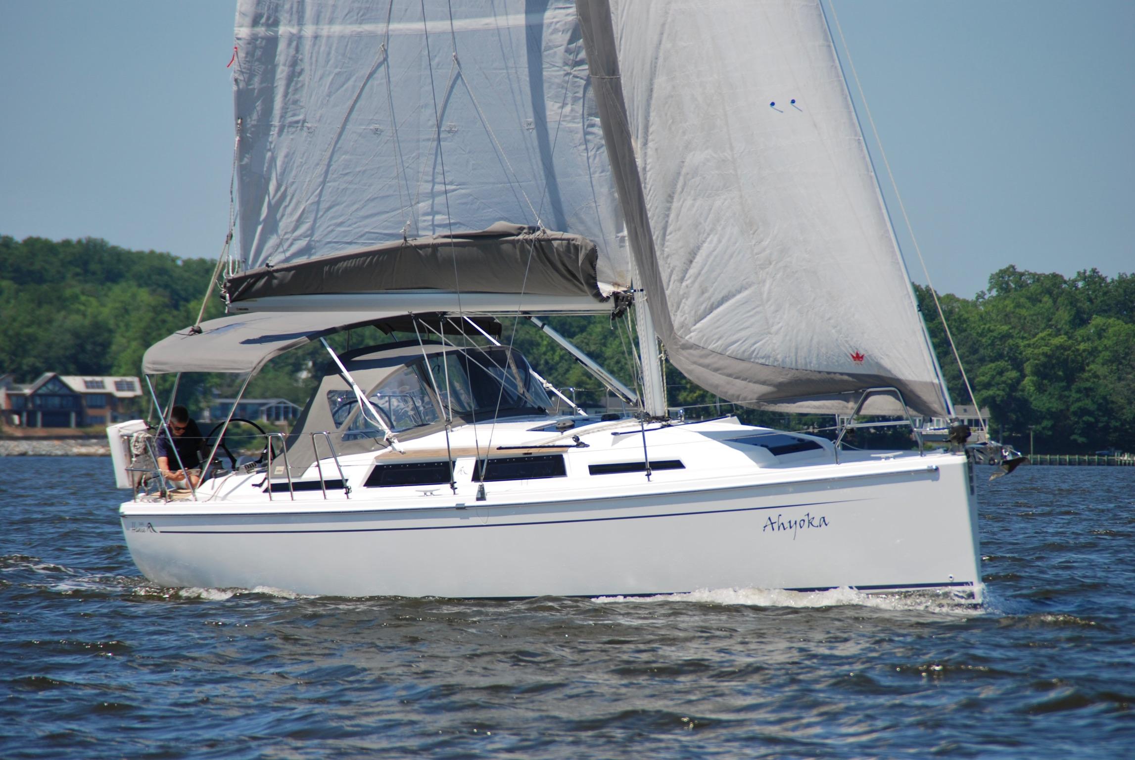 Hanse 345 2017 Hanse 345 sailboat cruising on a sunny day with lush green shoreline.