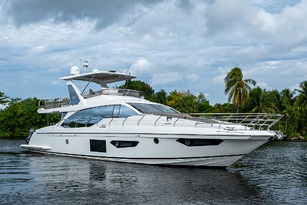 Azimut 66 2020 Azimut 66 yacht cruising on a serene waterway with lush greenery.