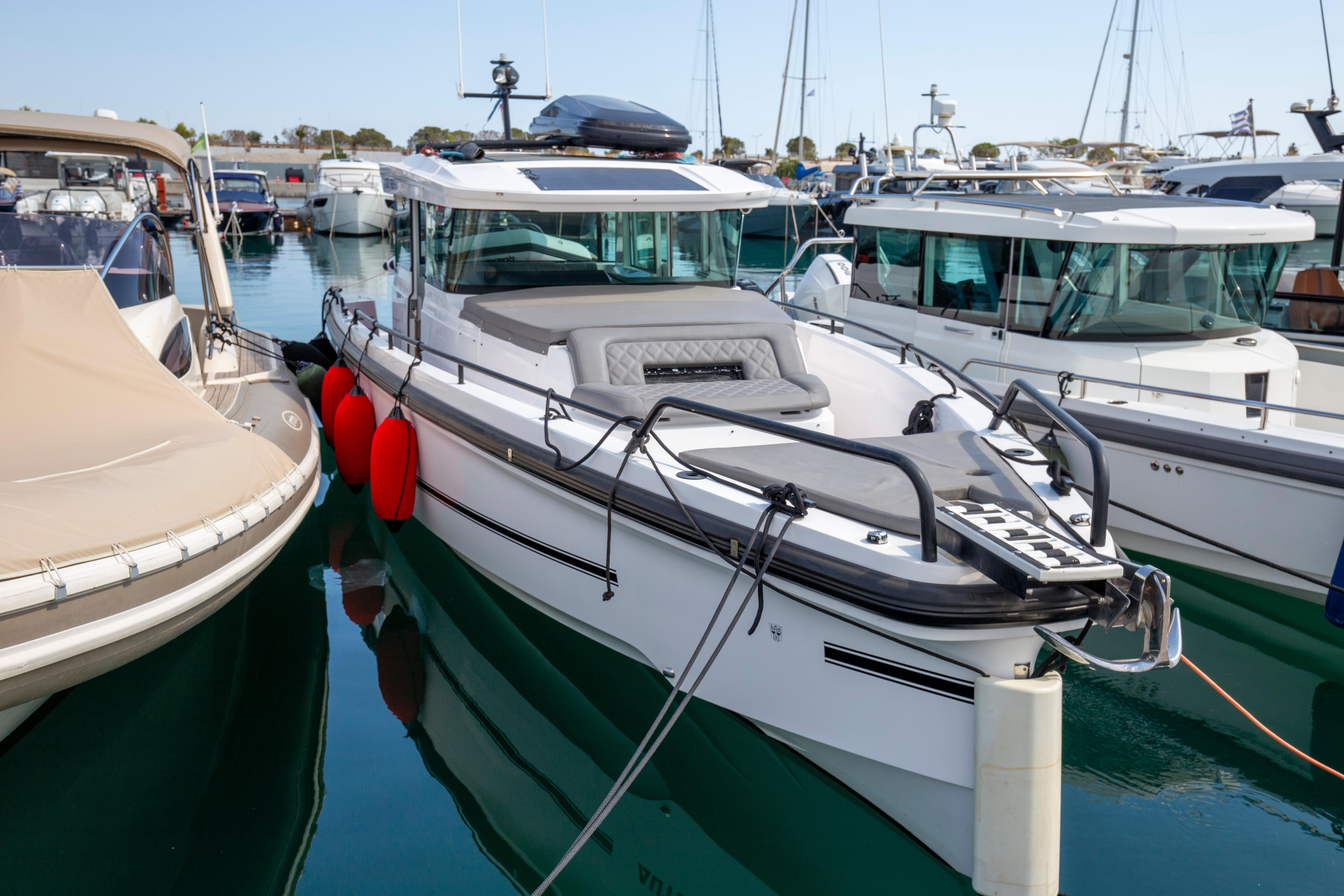 Axopar 37 XC 2021 Axopar 37 XC boat docked in a marina, surrounded by other vessels.