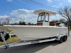 Sea Hunt Ultra 235 SE 2025 Sea Hunt Ultra 235 SE boat on trailer, parked on street under blue sky.