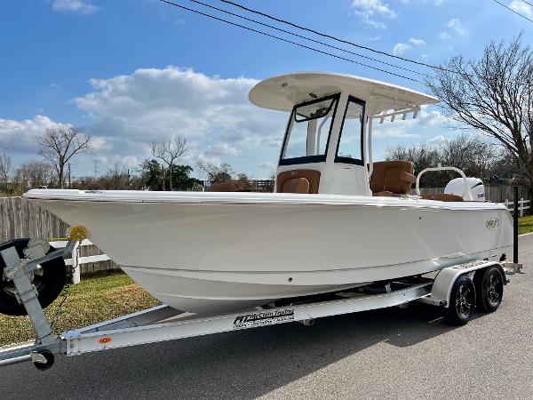 Sea Hunt Ultra 235 SE 2025 Sea Hunt Ultra 235 SE boat on trailer, parked on street under blue sky.