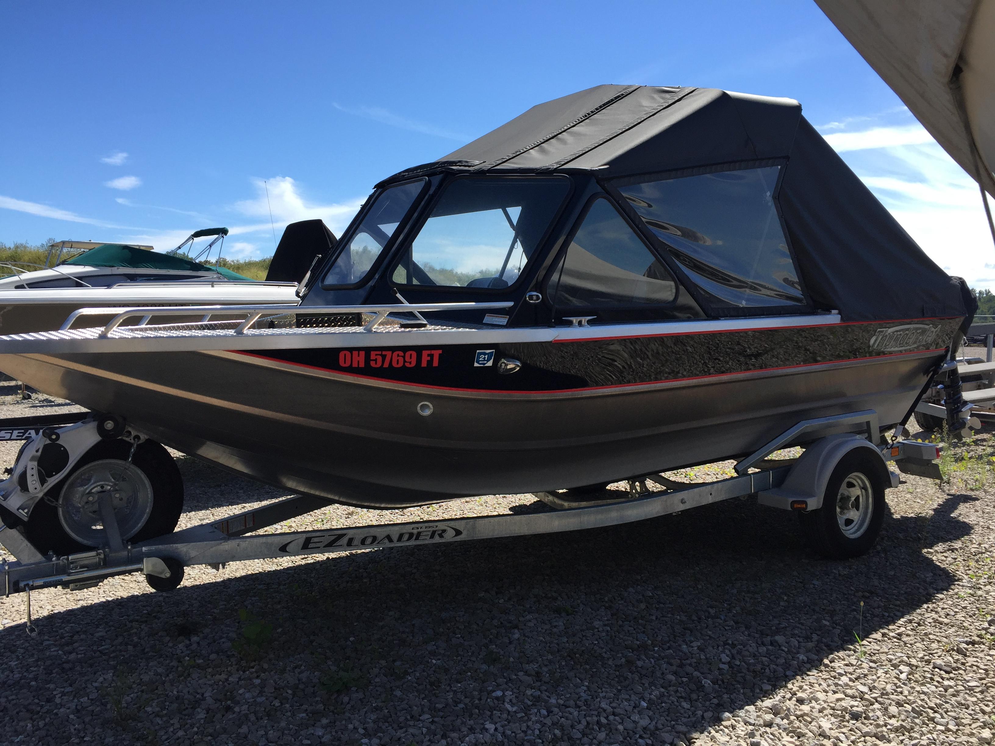 Thunder Jet T185EX 2018 Thunder Jet T185EX boat on trailer, black canopy, parked outdoors.