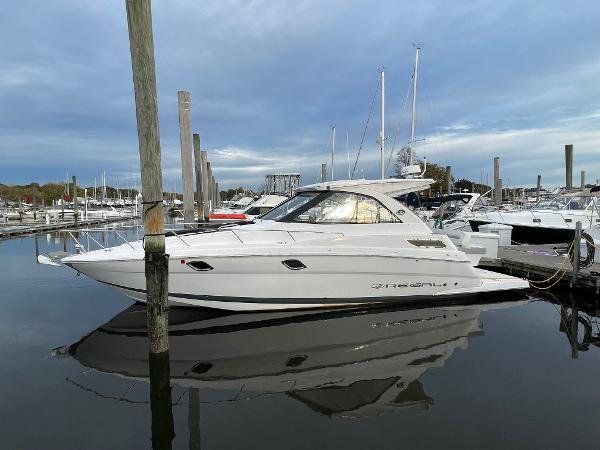 Regal 35 Sport Coupe 2021 Regal 35 Sport Coupe yacht docked in a marina, reflecting on calm water.