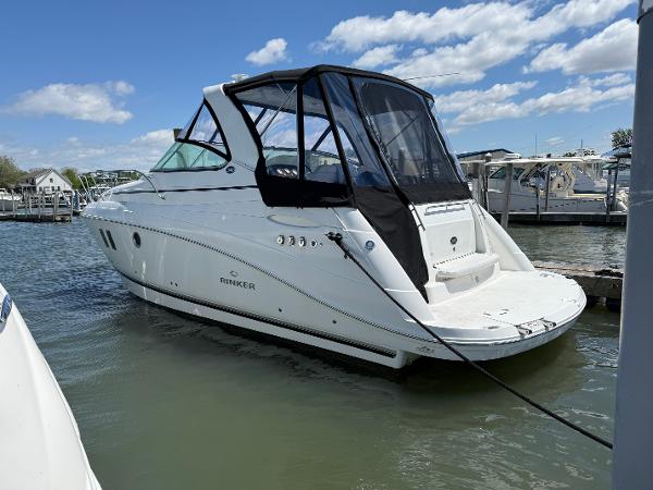 Rinker 340 Express Cruiser 2013 Rinker 340 Express Cruiser docked in a marina under a clear blue sky.
