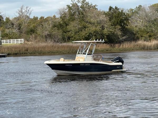 Scout 215 XSF 2022 Scout 215 XSF boat cruising on a calm river with trees in the background.