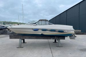Regal 1800 LSR 2000 Regal 1800 LSR boat on stand, with blue fenders, in a marina setting.
