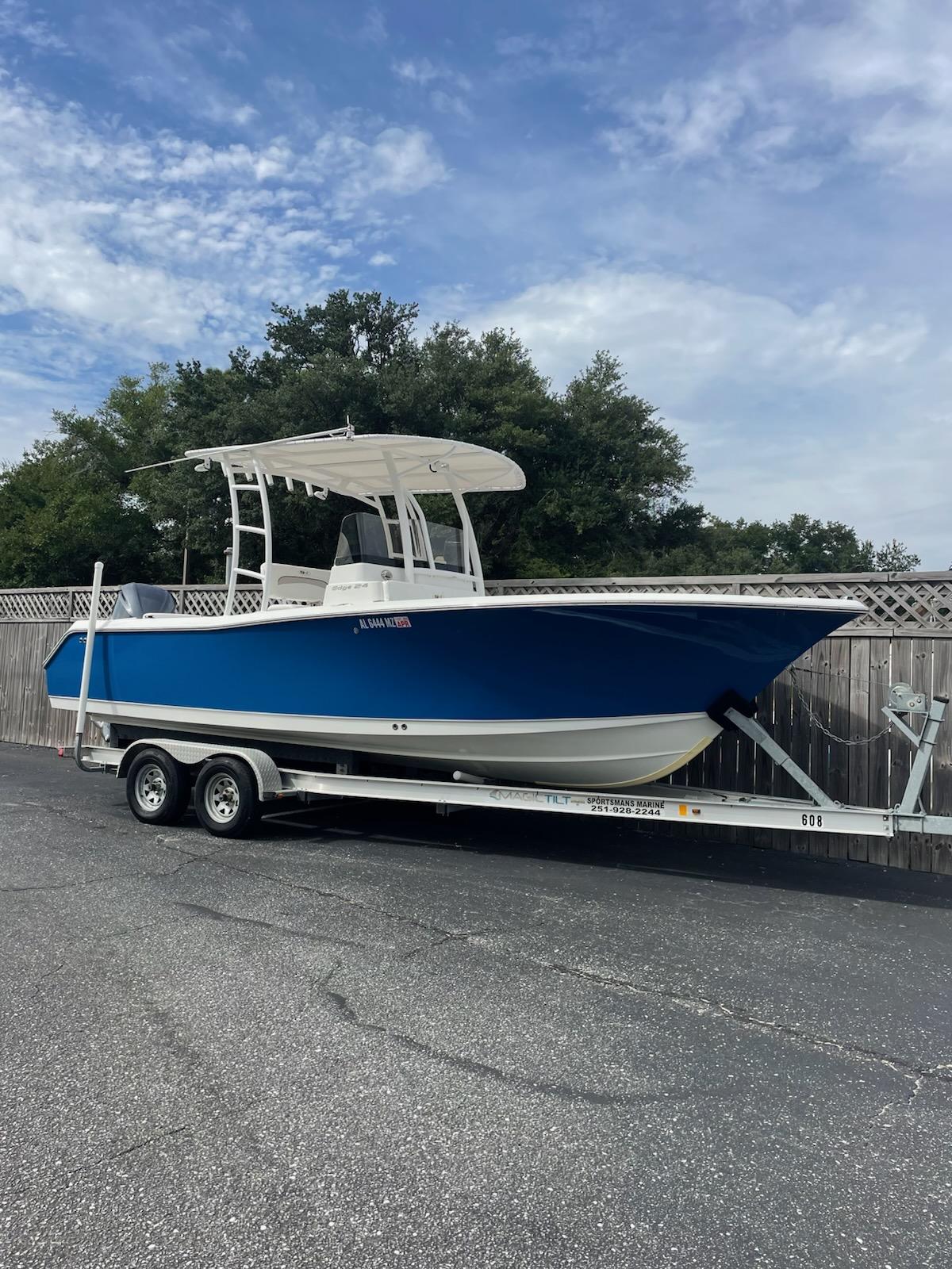 Sea Hunt Edge 24 2013 Sea Hunt Edge 24 boat on trailer, blue hull, parked outdoors.