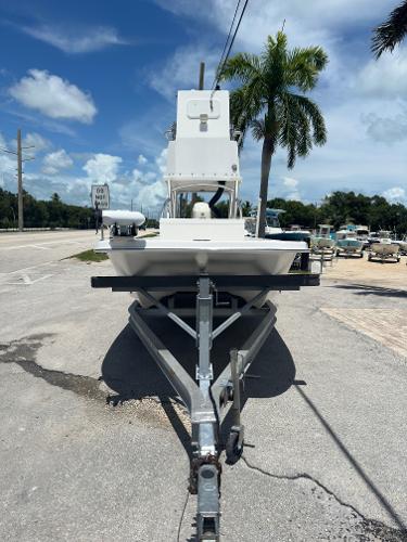 Twin Vee 22 Bay Cat 2015 Twin Vee 22 Bay Cat boat on trailer, parked roadside under palm trees.