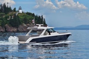 Tiara Yachts 43 LS 2024 Tiara Yachts 43 LS cruising near a scenic lighthouse and lush greenery.