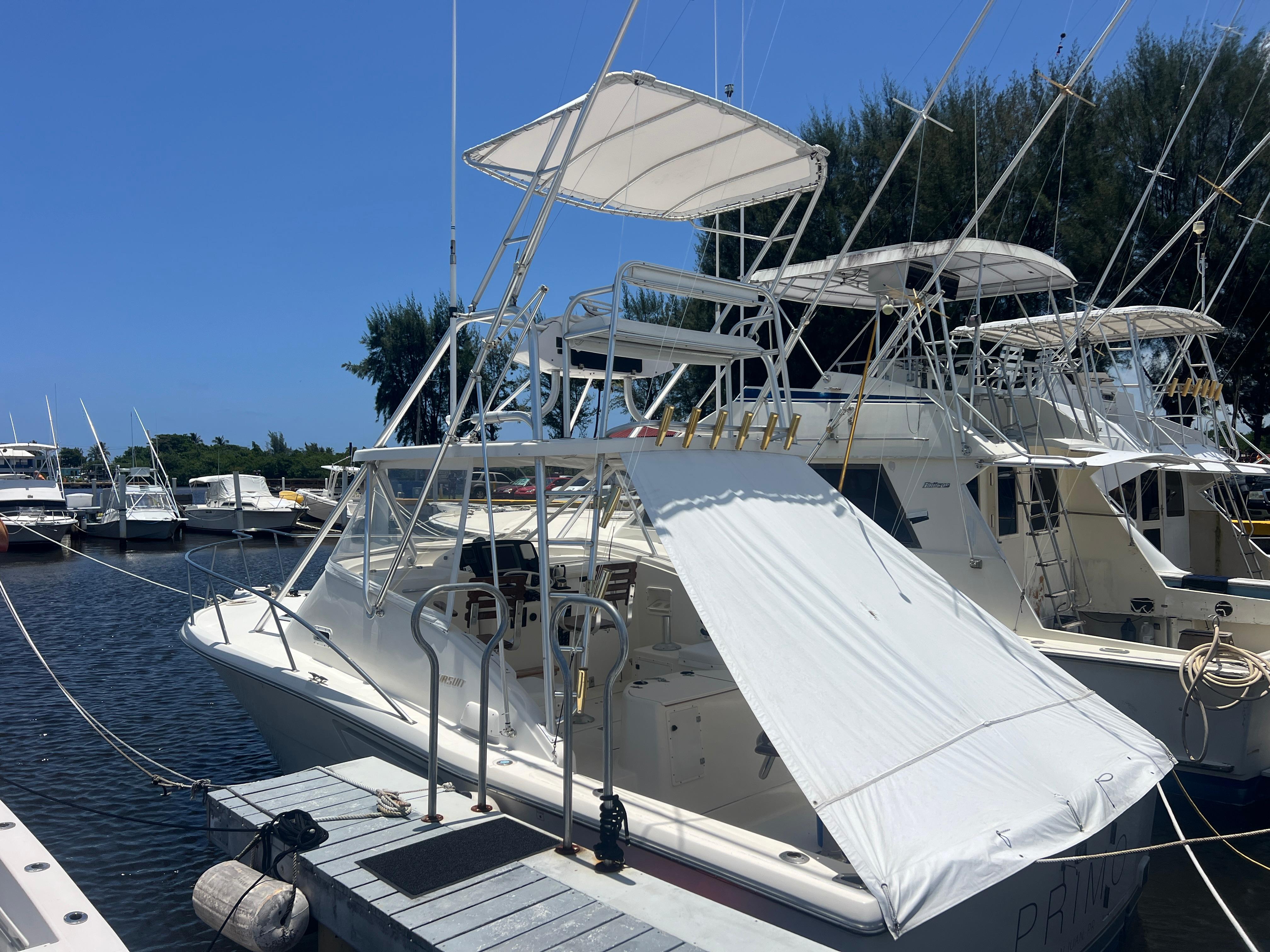 Pursuit 3000 Offshore Express 1997 Pursuit 3000 Offshore Express boat docked at marina under clear blue sky.