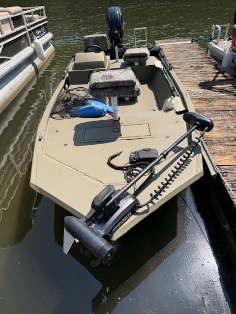 Tracker Grizzly 1648 SC 2024 Tracker Grizzly 1648 SC boat docked on calm water.