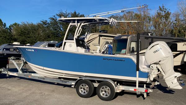 Sportsman Open 242 Center Console 2023 Sportsman Open 242 Center Console boat on trailer, blue hull, parked outdoors.