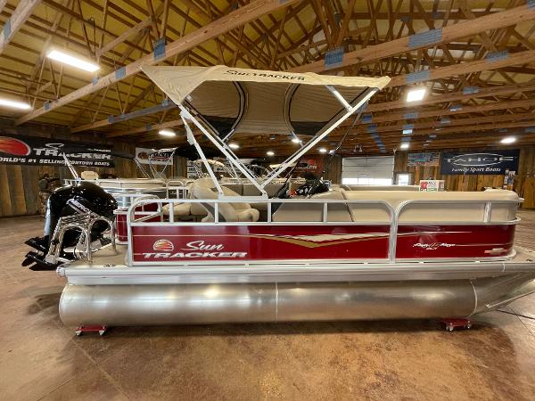 Sun Tracker Party Barge 18 DLX 2023 Sun Tracker Party Barge 18 DLX pontoon boat in a showroom.