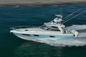 Intrepid 477 Evolution 2023 Intrepid 477 Evolution yacht cruising on ocean near sandy beach.