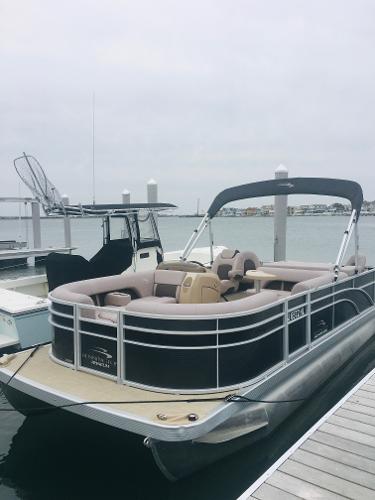 Bennington SX20 2018 Bennington SX20 pontoon boat docked at marina, overcast sky.