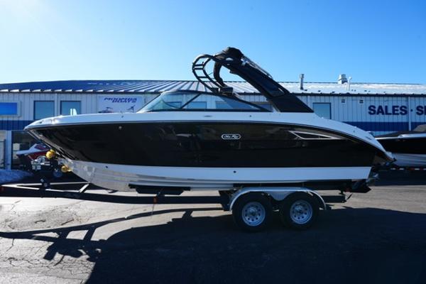 Sea Ray SDX 250 2025 Sea Ray SDX 250 boat on trailer, parked outside a sales showroom.