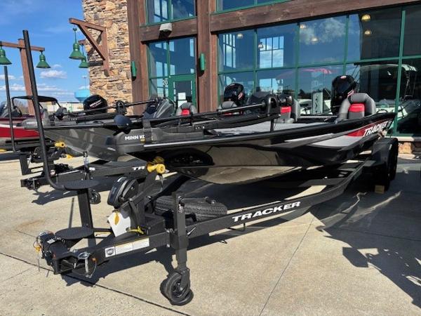 Tracker Savage 215 2025 Tracker Savage 215 boat on trailer, displayed outdoors near a building.