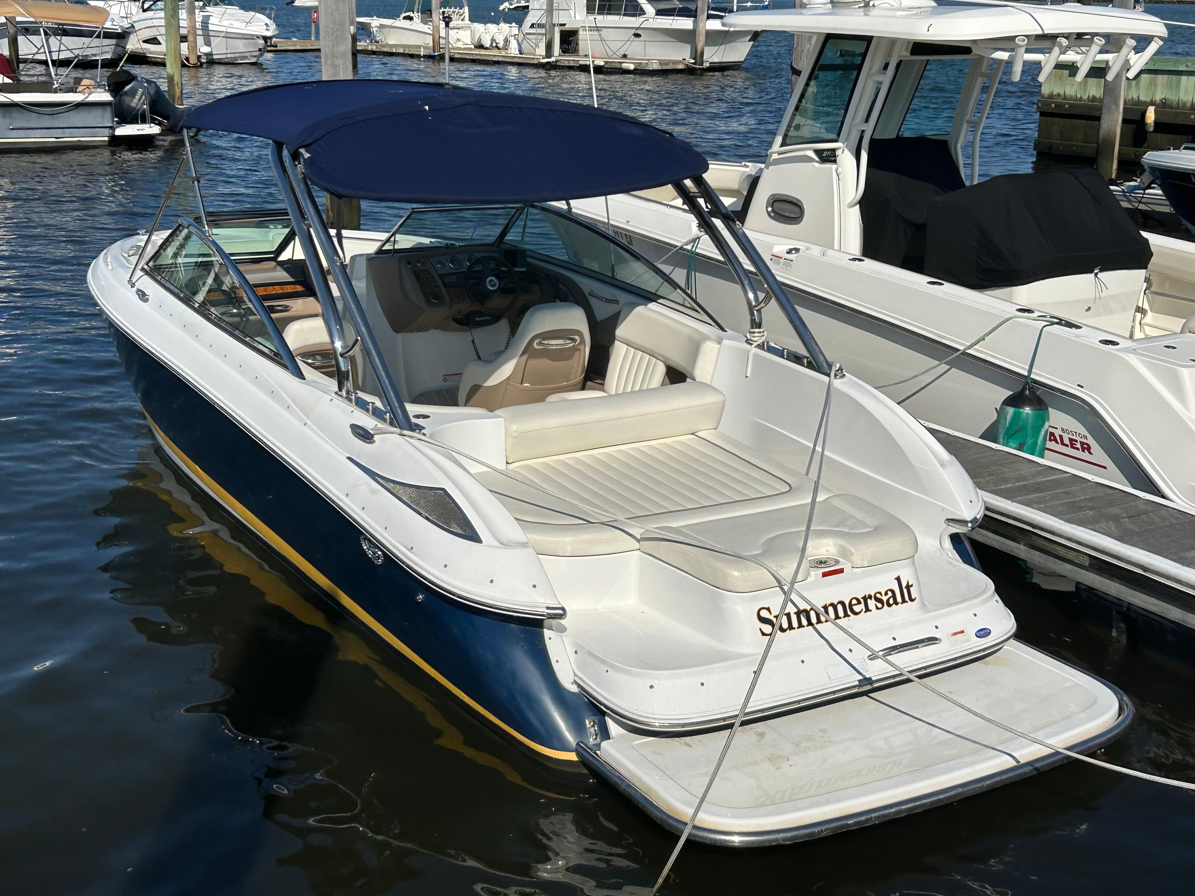 Cobalt 272 2008 Cobalt 272 boat docked, featuring a blue canopy and white seating.