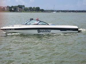 Malibu Response LX 2000 Malibu Response LX boat cruising on a lake with a driver.