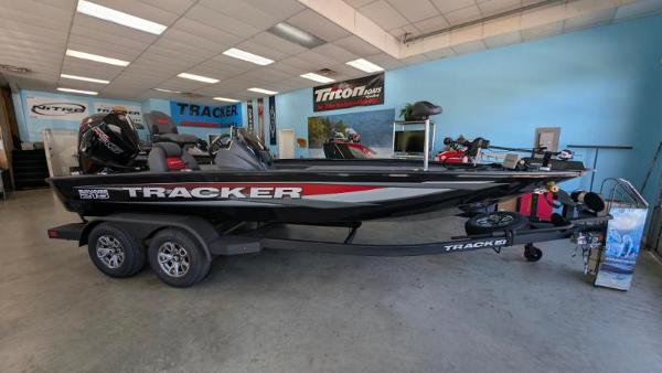 Tracker Savage 215 2025 Tracker Savage 215 boat displayed in showroom with trailer.