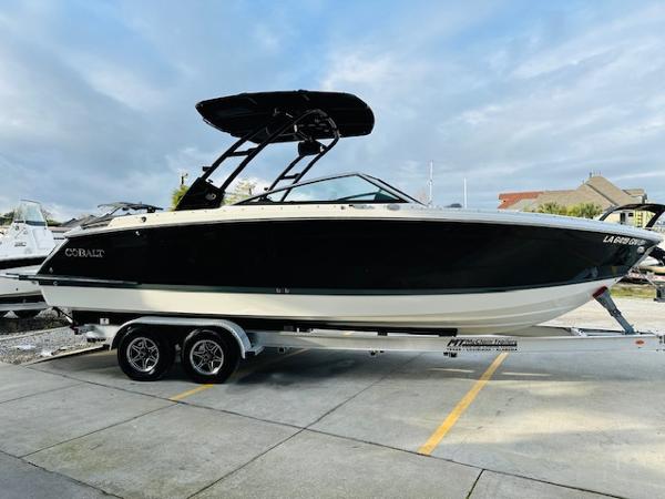 Cobalt R8 2022 Cobalt R8 boat on trailer, black hull, sleek design, parked outdoors.