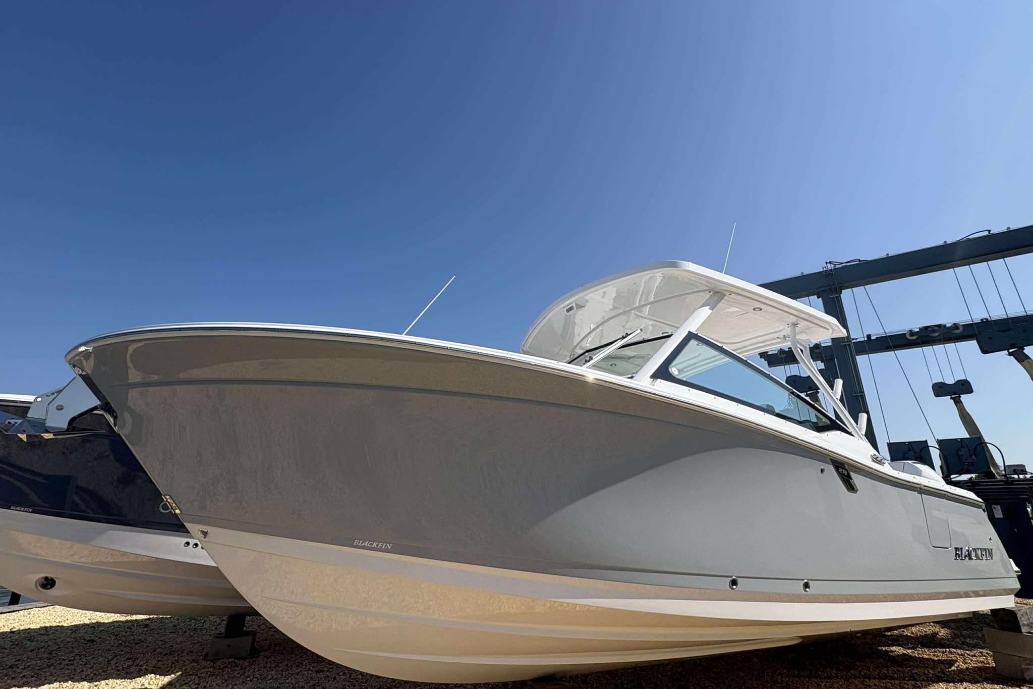 Blackfin 272 DC 2026 Blackfin 272 DC boat under clear blue sky, side view.