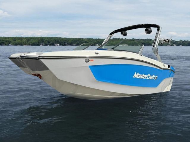 MasterCraft XT20 2024 MasterCraft XT20 boat on a lake, featuring sleek design and blue accents.