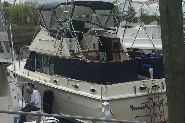 Hatteras 38 DC 1976 Hatteras 38 DC yacht docked at a marina, featuring a spacious deck and canopy.