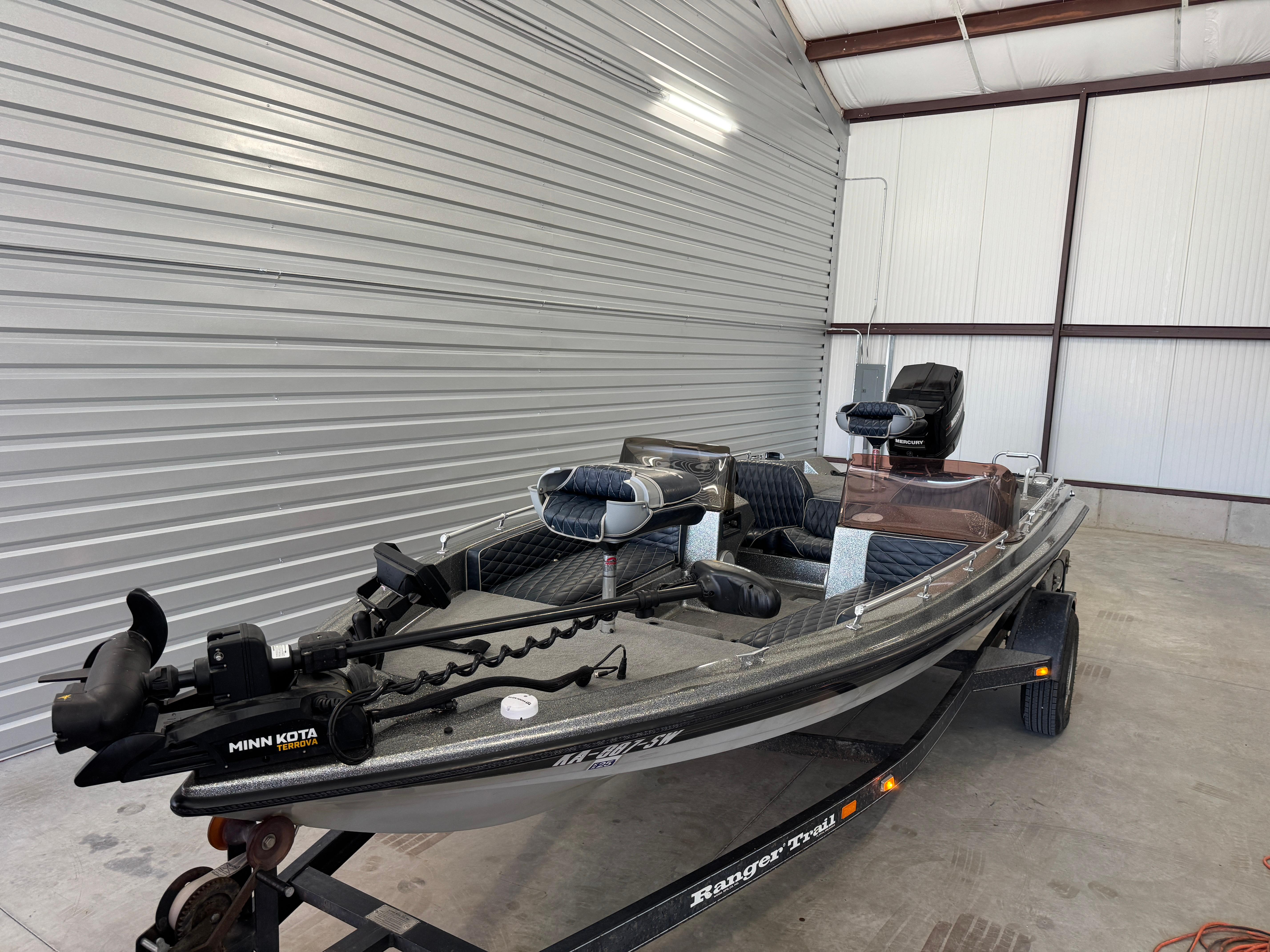 Ranger 375V 1989 Ranger 375V boat with Minn Kota motor in a garage setting.